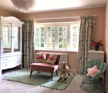 Girls bedroom in pastel pink and green, with butterfly curtains.