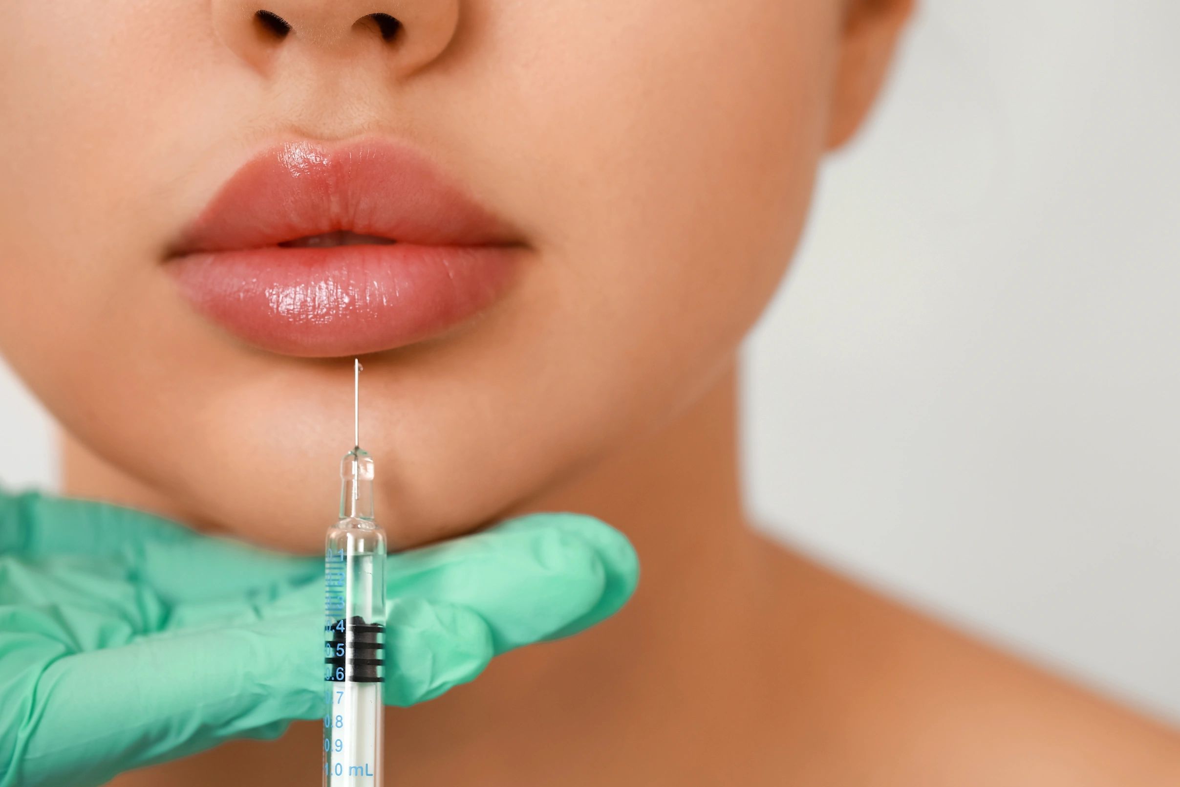 close picture of lips and a syringe