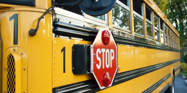 Close-up of a yellow school bus with an extended stop sign.