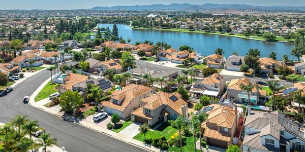 Aerial view of suburban neighborhood with houses and a lake.