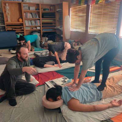 People participating in a massage workshop in a cozy room.