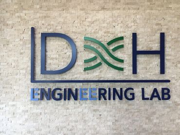 1/2" Acrylic logo installed into stone accent wall with studs and silicone.