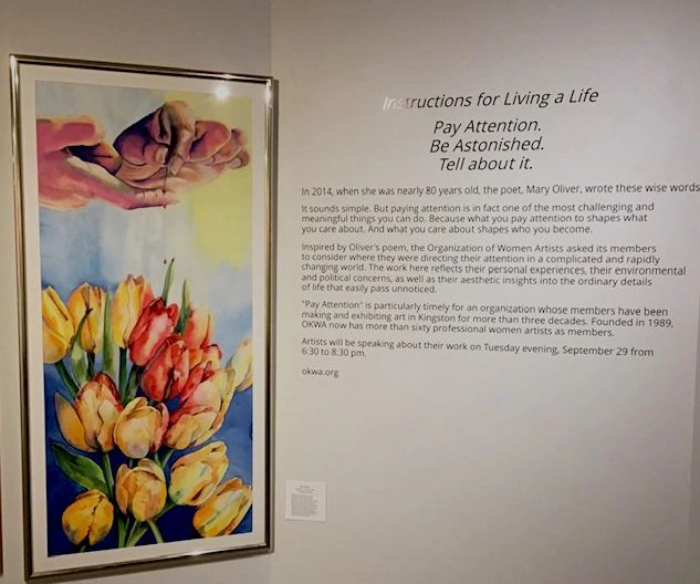 Colorful floral painting displayed next to descriptive wall text about 'Living a Life'.