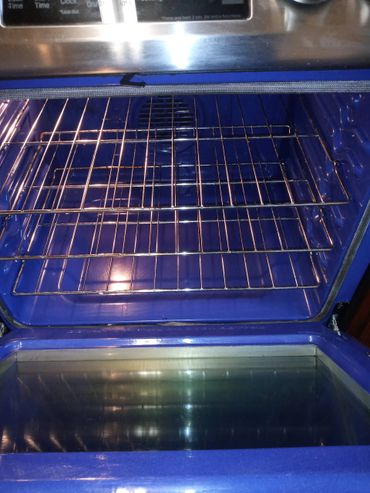 Clean blue oven interior with metal racks and an open glass door.