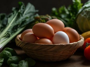 A basket of farm fresh eggs and produce