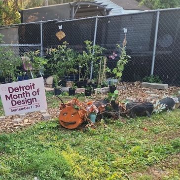 A creative garden display with a pumpkin face and plants.