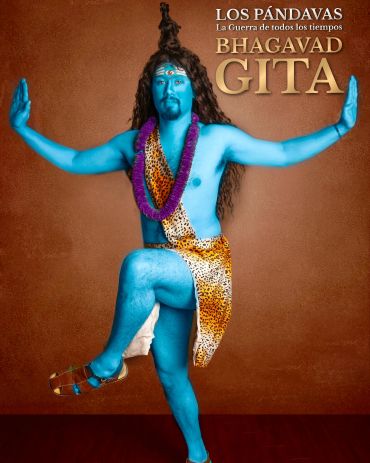 A man painted blue poses as a deity on a book cover of Bhagavad Gita.