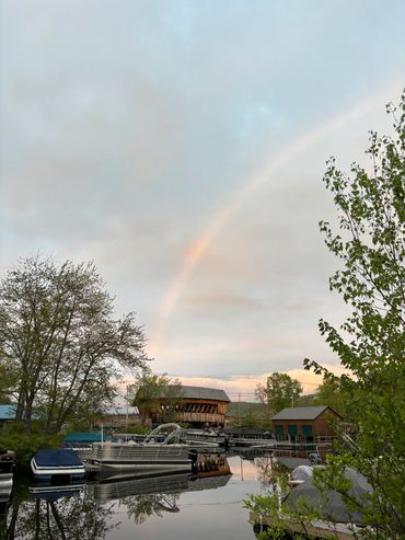 picture of marina with covered bridge and rainbow in background