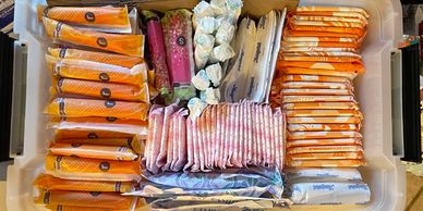 Organized box of various feminine hygiene products including pads and tampons.