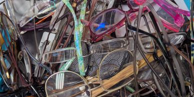 A pile of various eyeglasses with different frame styles and colors.