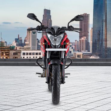 Red and black motorcycle parked on a tiled rooftop with city skyline in background.