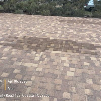 Roof shingles showing a rectangular patch of discoloration.