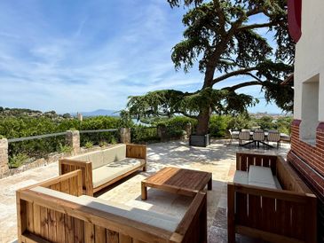 Outdoor patio with wooden furniture and scenic view under a clear sky.