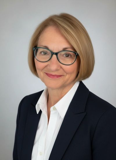 Professional woman with glasses and a friendly smile in business attire.