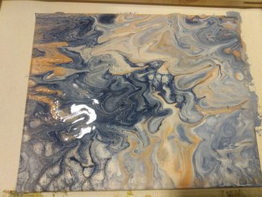 Abstract fluid art with swirling blue, beige, and gold tones.