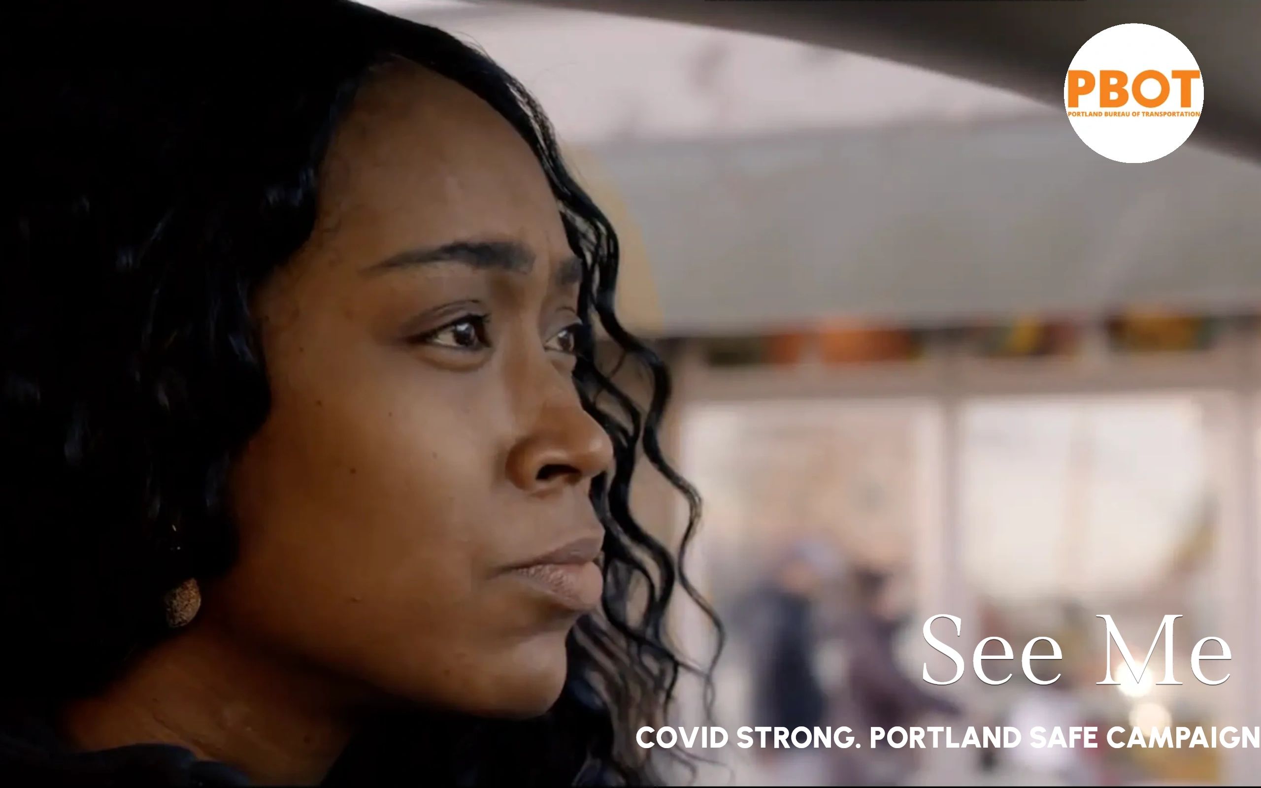 Close-up of a woman looking thoughtfully to the side with COVID safety campaign text.