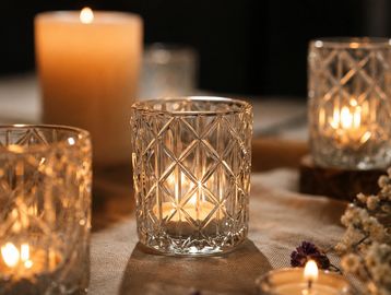Decorative glass candle holders with lit candles.