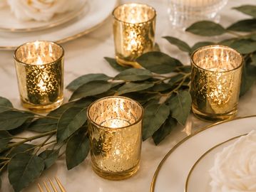 Elegant gold votive candle holders on leaves.