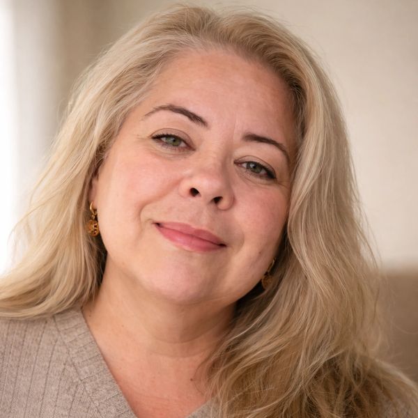 Portrait of a smiling woman with blonde hair and light makeup.