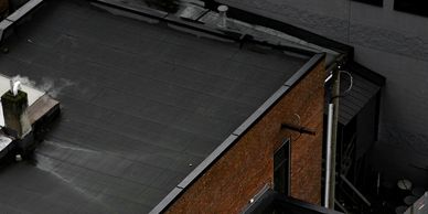 An image looking down on a commercial roof on a brick building