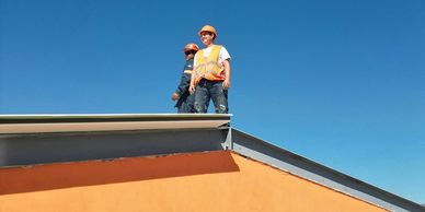 Two men standing on a roof inspecting it.