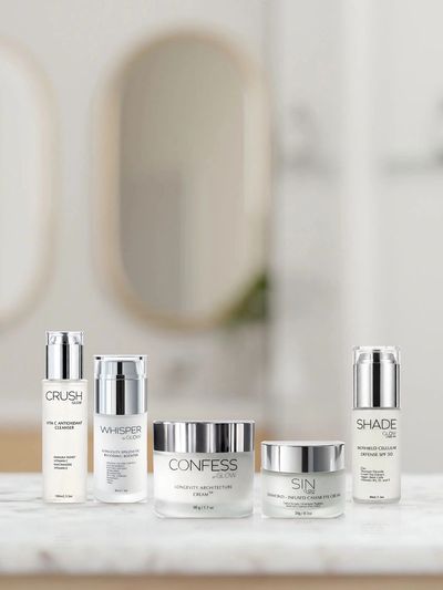 GLOW anti-aging day ritual: Crush, Whisper, Confess, Sin and Shade SPF50 on a marble bathroom counte
