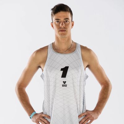 Athletic man in white sports jersey with number 1 stands confidently with hands on hips.