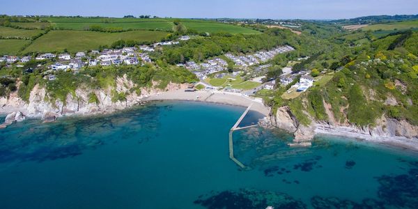 Coastal village with clear blue water and cliffs.