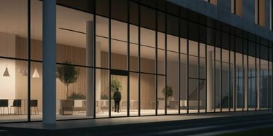 Modern building with large glass windows illuminated at night.