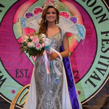 Beauty queen smiling with bouquet and crown.
