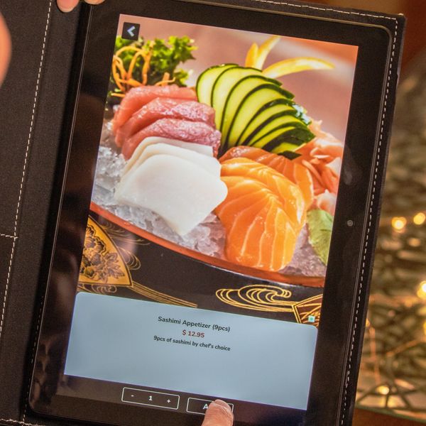 Beautiful Asian woman holding a Smart Tech Menu's Digital Menu Tablet.