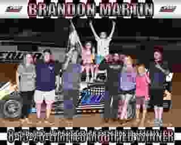 Racing celebration with driver on car roof and team.