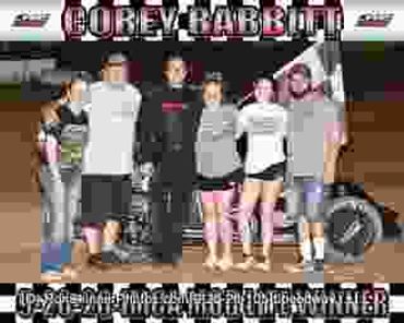 Group photo with racecar and trophies at Corey-Dabbit race event.