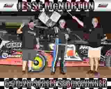 Race car driver and team celebrate victory with checkered flags.