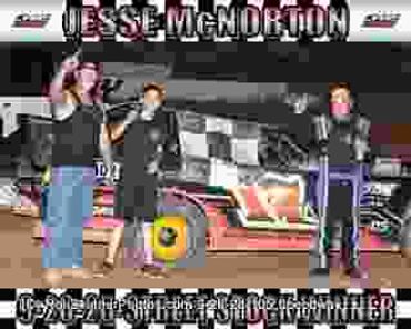 Two people celebrating at a race winner's circle with a driver.