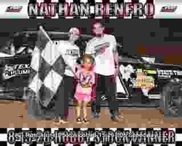 Two men and a child celebrating near a race car with a checkered flag.