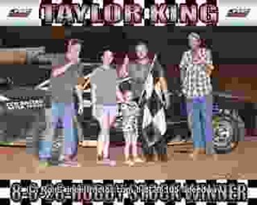 Family celebrating a racing win under a Taylor King banner.