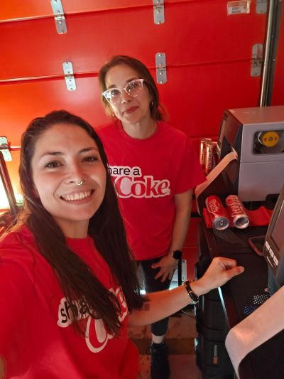 Brand ambassadors in branded Share a Coke shirts staffing a beverage sampling event