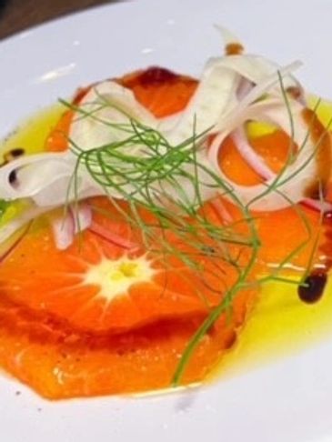 Gourmet citrus carpaccio garnished with fennel and thinly sliced onions.