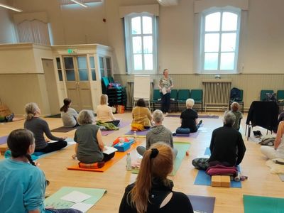 Group of Yoga Teachers sitting on their mats and taking part in a a Continued Professional Developme
