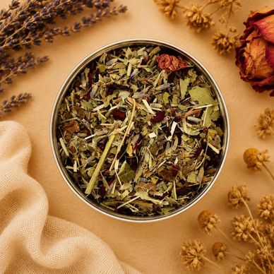 Herbal tea blend in a round tin with dried flowers and fabric.