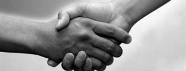Two hands firmly shaking in a black and white photo.