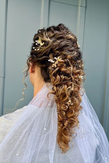 Elegant curly updo with gold butterfly hair accessories and veil.