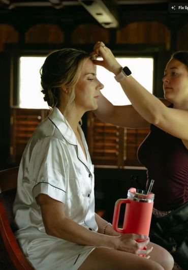 Bride getting wedding day hair done while relaxing.