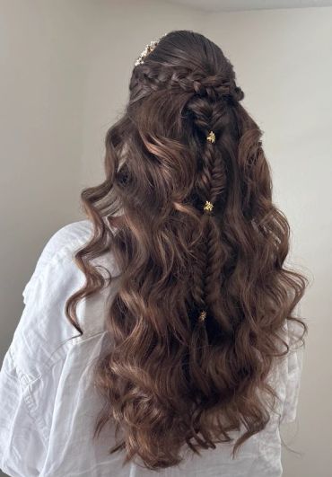 Long brown curly waved hair styled with braids and small golden clips.
