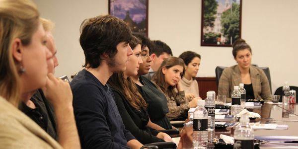 A group of undergraduate university students sit at a seminar table.