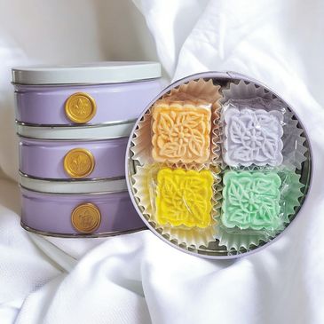 Purple tin with four individually wrapped two ounce shower steamers. Orange ginger, lavender & chamo
