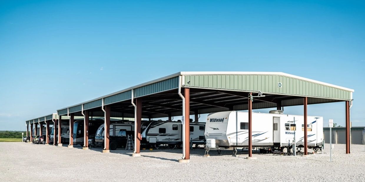 RV's parked under metal overhang. Covered RV Sites at Texas Lakes Ranch RV Park & Storage in Texas
