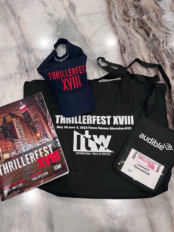 ThrillerFest XVIII event merchandise and badge on a marble surface.