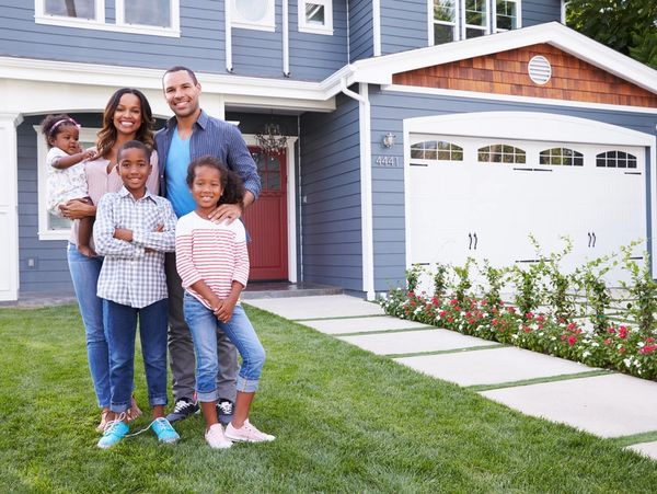 Happy black family standing outside their house